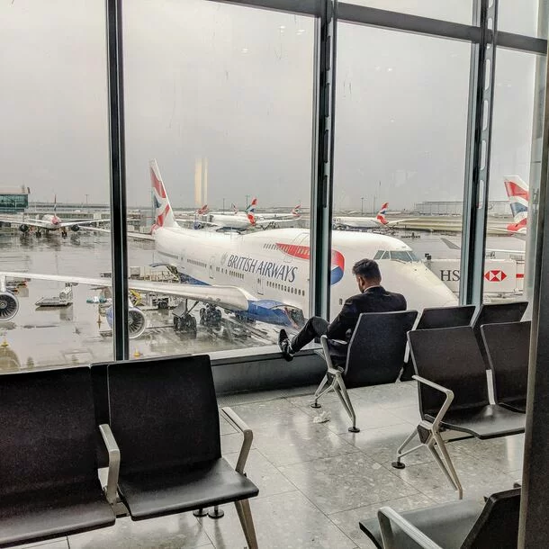 Der Flughafen Heathrow London (LHR) in Longford, Vereinigtes Königreich, beeindruckt mit seinem grauen Ambiente. Hier treffen sich Menschen aus aller Welt, um ihre Reise anzutreten oder anzukommen. Das geschäftige Terminal ist gefüllt mit Menschen, die auf Möbeln sitzen und auf ihren Flug warten. Flugzeuge, darunter der ikonische 747, stehen bereit, um Passagiere an entfernte Orte zu transportieren. Der Flughafen Heathrow ist ein bedeutender Verkehrsknotenpunkt und bietet drinnen eine geschäftige Atmosphäre. Er ist ein lebhaftes Zentrum des Transports und ein Ort, der auf vielen People-Bildern und -Fotos verewigt wird