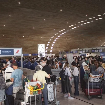 Personen mit Koffern am Flughafen sind gestresst wegen FTI Insolvenz